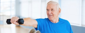 An older man in a blue shirt exercises with a dumbbell, embracing digital healthcare for fitness, as promoted by medbridge.