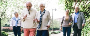 A group of seniors enjoys a sunny walk, benefiting from Medbridge digital healthcare tools.