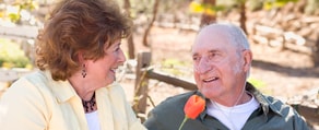 A woman and a man with an oxygen tube enjoy fresh air outdoors, embodying medbridge's hybrid care philosophy amidst nature.