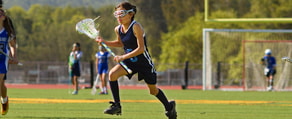 A girl in sports gear runs across a lacrosse field with her stick, showcasing the precision and teamwork emphasized by Medbridge.