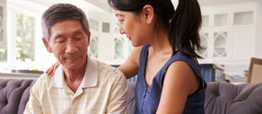 A young woman in a blue top supports an elderly man, illustrating medbridge's role in modern patient care.