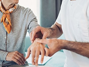 Clinician examining a patient's wrist and hand during a carpal tunnel syndrome assessment.