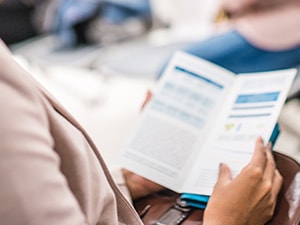 Individual reading a brochure in a Medbridge waiting area.