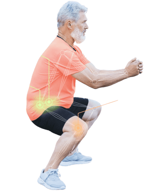 An elderly man in an orange shirt and black shorts demonstrates a squat with movement and joint points shown, as seen on medbridge.