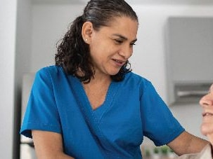 Home health nurse speaking with an older adult patient in a home setting, representing home health care industry trends and support.