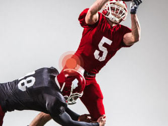 Medbridge players: red #5 leaps for a catch as black #18 attempts a tackle.