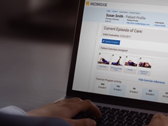 Person looking at a laptop showing the medbridge medical portal with patient info and exercise tasks.