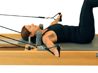 Individual using a Pilates reformer at medbridge.