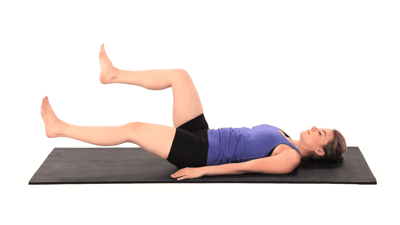 Person on a yoga mat doing a leg lift, wearing a blue tank top and black shorts for medbridge.