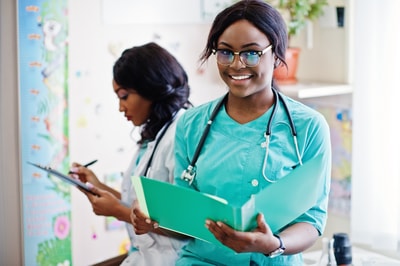 Two healthcare professionals in scrubs and lab coats collaborate, highlighting medbridge's commitment to enhancing patient care through continuous training.