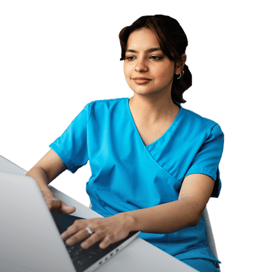 A person in blue scrubs uses a laptop for digital healthcare tasks.