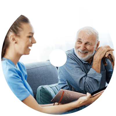 Medbridge patient smiling at healthcare worker with blood pressure monitor.