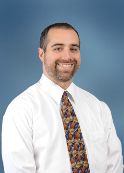 A confident man in a white shirt and colorful tie represents medbridge's hybrid care solutions.