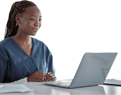 A person in blue scrubs smiles while using medbridge on a laptop.
