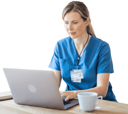 A person in a blue medical uniform uses a laptop beside a medbridge ID and white mug.