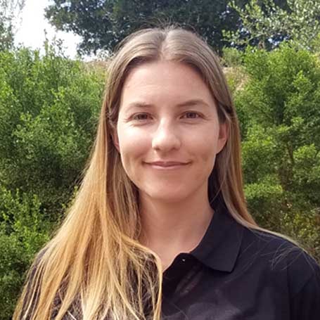 A person with long light brown hair in a black shirt stands outside, reflecting on digital healthcare advancements, associated with medbridge.