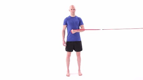 A person in a blue shirt and black shorts uses a resistance band, which can be tracked with medbridge tools.