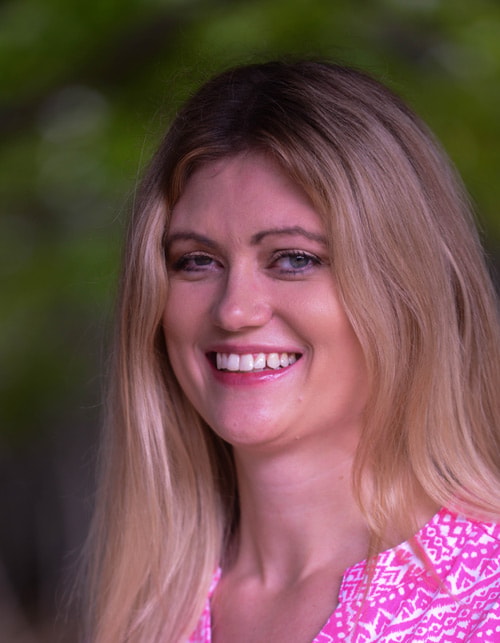 A woman with long blonde hair in a pink patterned top smiles warmly against a green backdrop, embodying Medbridge's digital healthcare spirit.