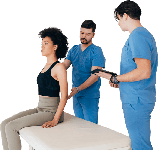 A woman on a medical table is assessed for posture by two people in blue scrubs, showcasing medbridge training techniques.