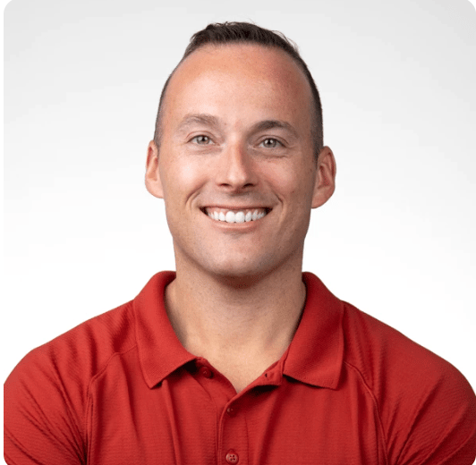 Smiling man with short hair in a red polo shirt against a white background, representing medbridge in digital healthcare.