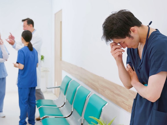A nurse in scrubs appears distressed while medbridge professionals converse nearby.