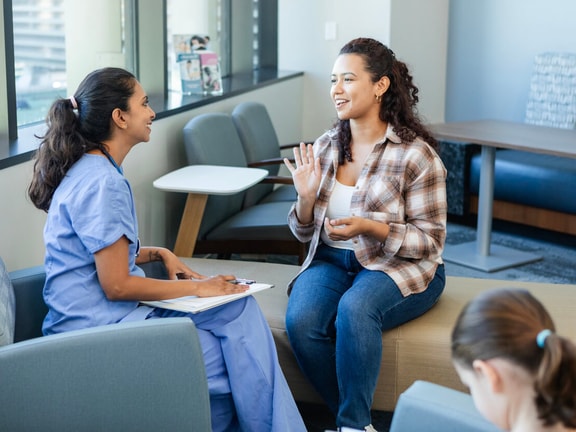 Clinician and patient talking in a healthcare setting, demonstrating active listening in healthcare through open, engaged body language.
