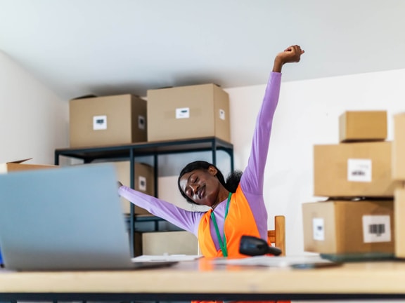 Warehouse employee stretching at desk, highlighting the role of advanced primary care in workplace musculoskeletal health.