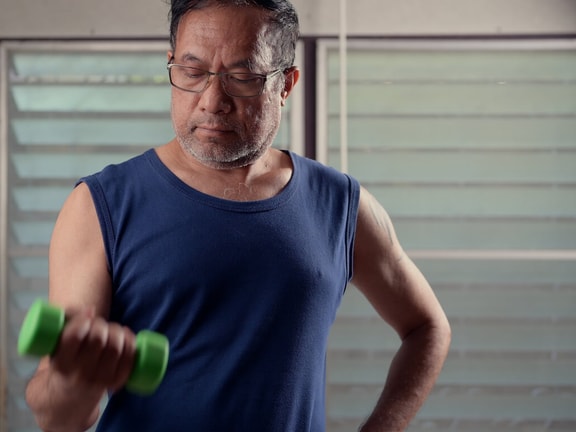 man lifting dumbbell - Daily Undulating Periodization