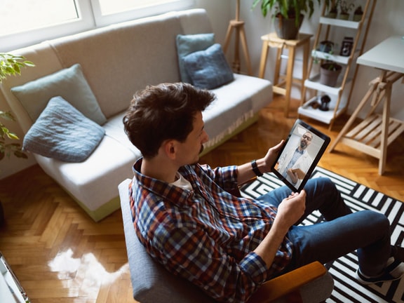 A man has a video call on a tablet for digital healthcare with medbridge.