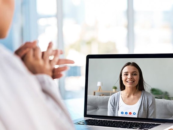 Video call on a laptop with Medbridge in a bright room.