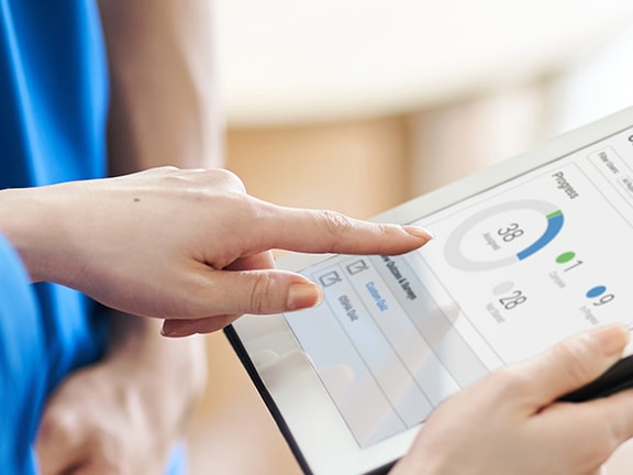 User interacting with a tablet showing the medbridge health app.
