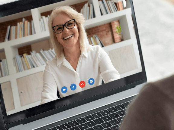 A medbridge video call shows a smiling person with short hair and glasses on a laptop screen.