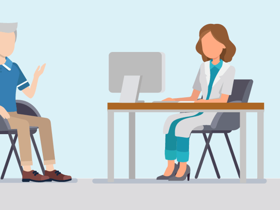 In a medical office, an elderly man in a blue shirt speaks with a female doctor at her desk.