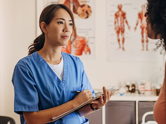 A healthcare professional talks to a patient in an office with Medbridge branding.