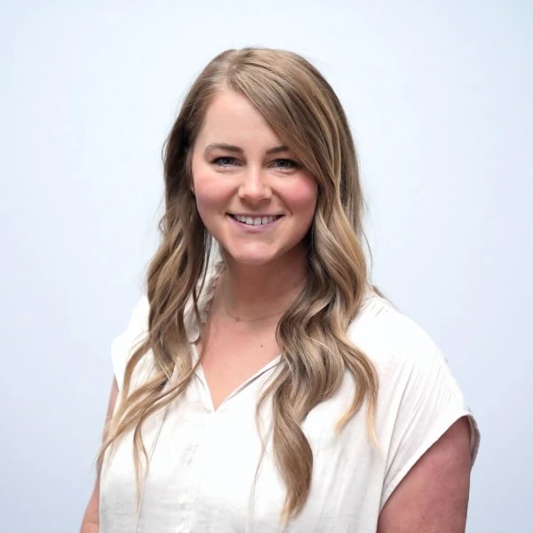 A smiling woman in a white blouse represents digital healthcare for Medbridge.