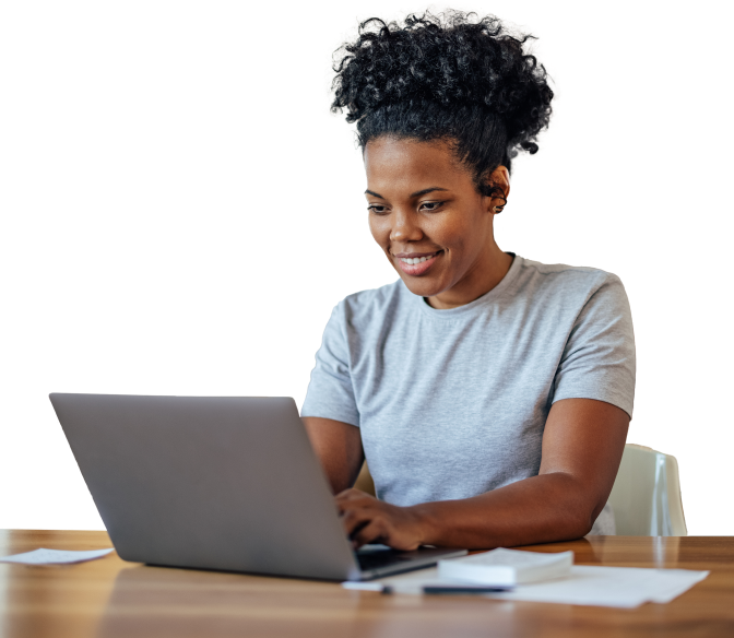 A woman in a gray shirt works on a laptop with nearby papers and a notebook, representing Medbridge.