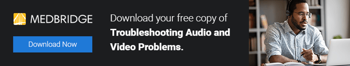 Banner for medbridge: A man with glasses uses a laptop to offer a free guide on fixing audio and video issues.