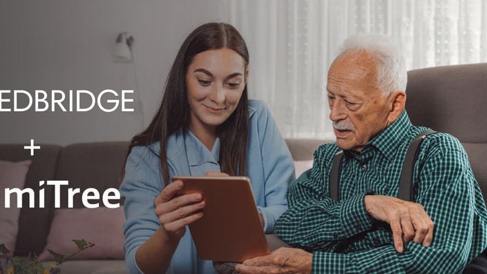 A young woman and an elderly man explore patient care software on a tablet, with medBridge and SimiTree logos visible.